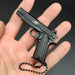 1:3 1911 Scale Handgun - Black die cast metal miniature with working safety and slide held in hand with black chain.