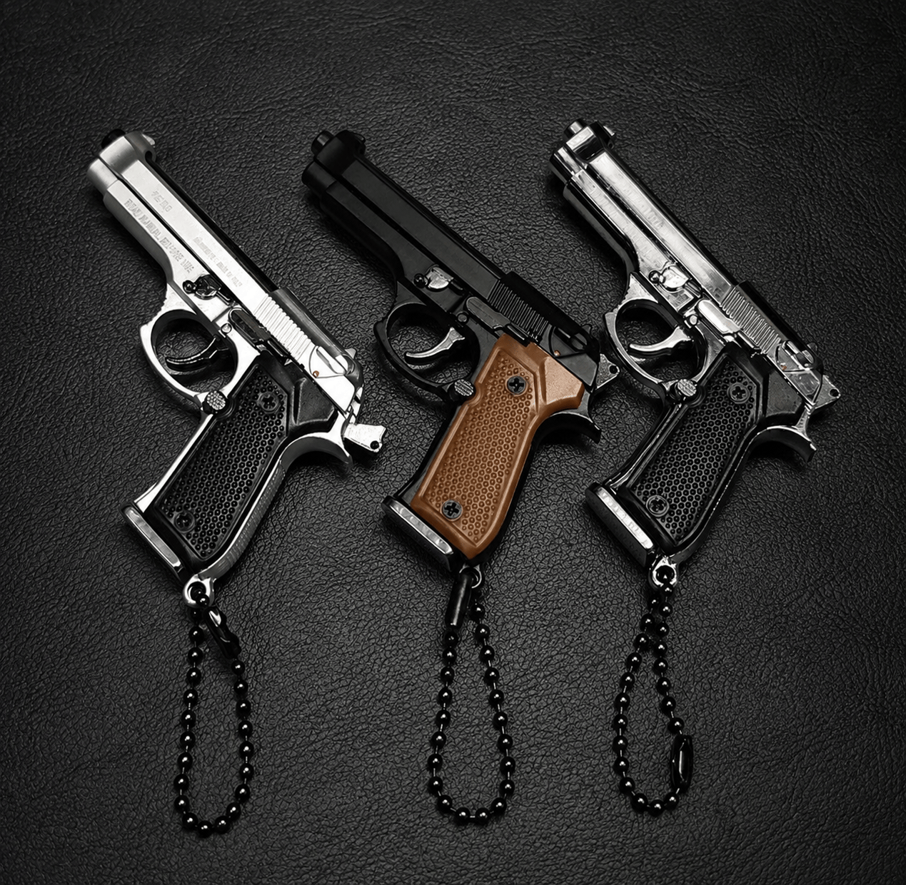 Three small guns with chains on a dark background