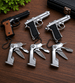 Keychain guns and multi-tools on a wooden surface with a plant in the corner.