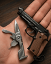 Pistool and multi-tool on a hand with wooden background