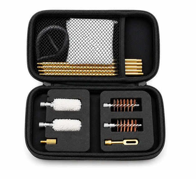An open black zippered carrying case displaying a cleaning kit with various brass and silver cleaning tools, two white brush rollers, and a black mesh bag containing a cloth and black accessory.