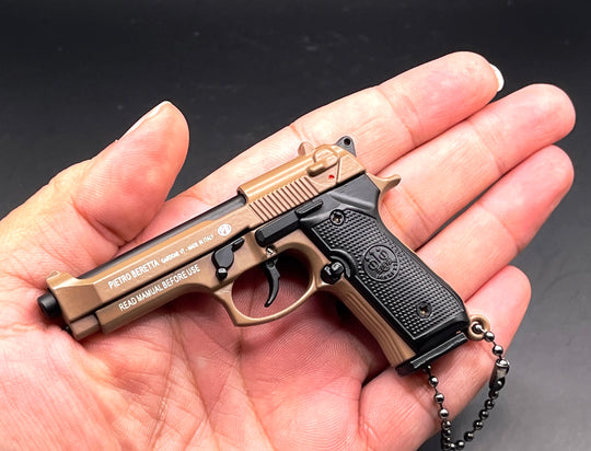 1:3 Beretta 92FS Handgun - Desert Tan miniature model with working safety and slide held in a hand.