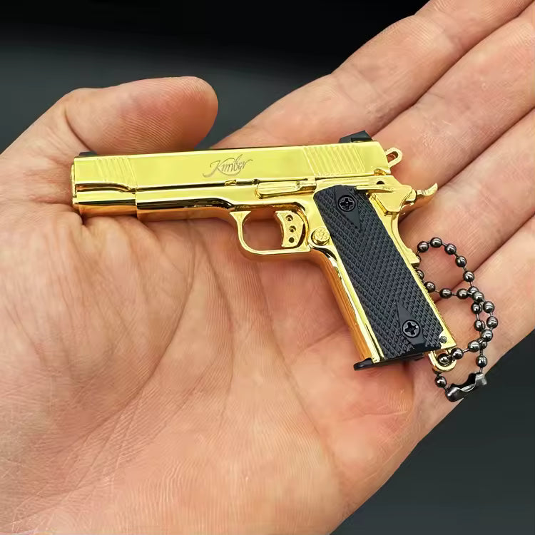 1:3 1911 Scale Handgun - Gold miniature replica with black grips held in a hand, detailed die cast metal parts