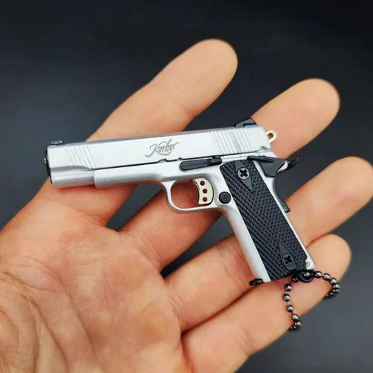 1:3 1911 Scale Handgun - Silver miniature model with die cast metal parts, functional safety, and slide in hand.