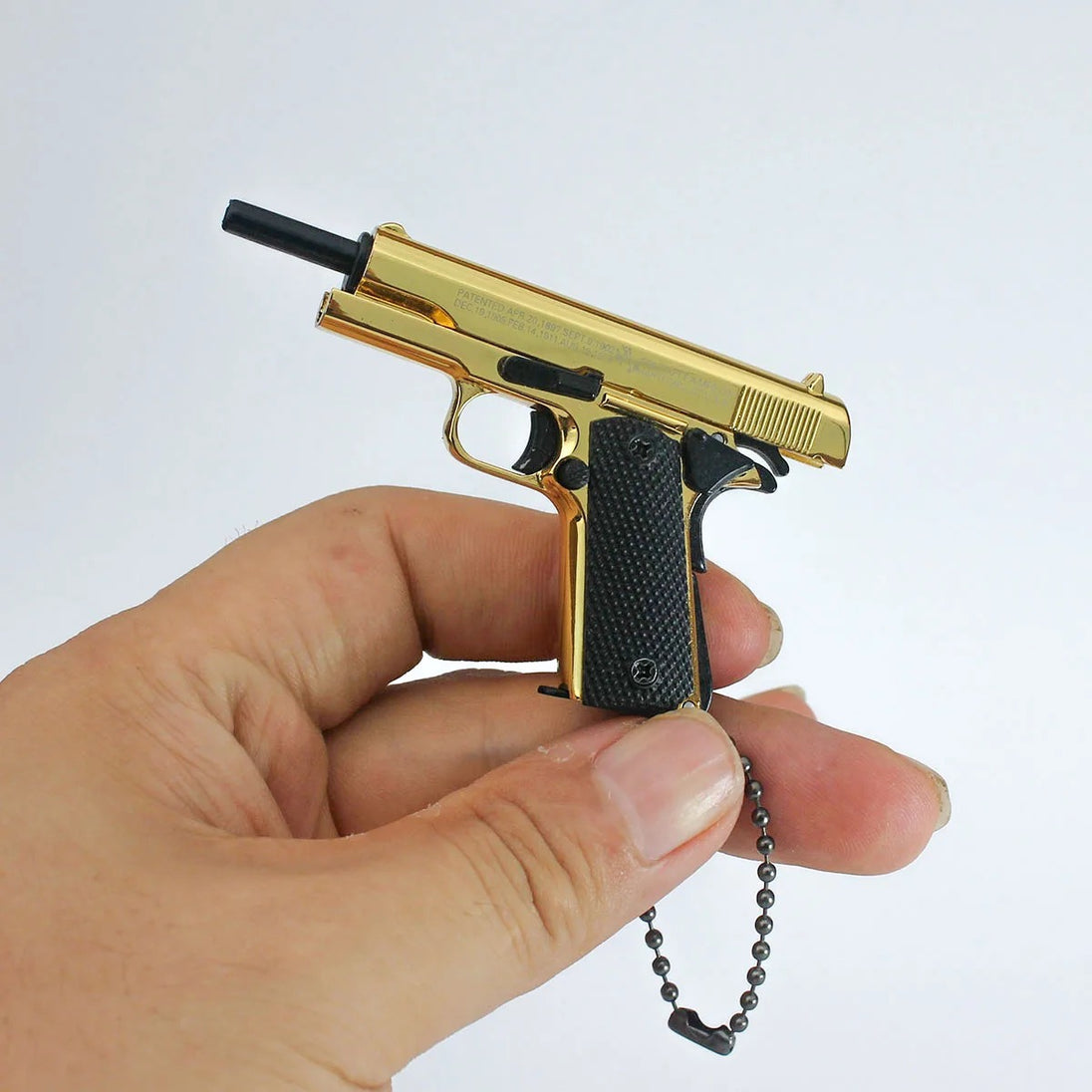 1:3 1911 Scale Handgun - Gold miniature die cast model with functional slide and safety held in hand.