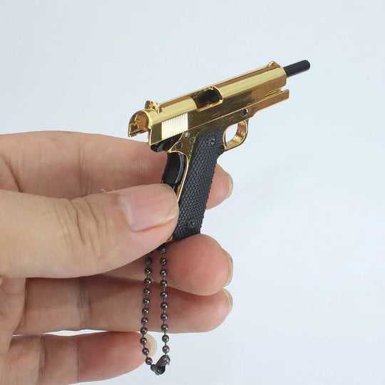 1:3 1911 Scale Handgun - Gold miniature model held in hand with die cast gold parts and black grips.