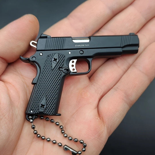 1:3 1911 Scale Handgun - Black miniature die cast metal model with working safety and slide, held in palm of hand.