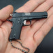 1:3 1911 Scale Handgun - Black miniature die cast metal model with working safety and slide, held in palm of hand.